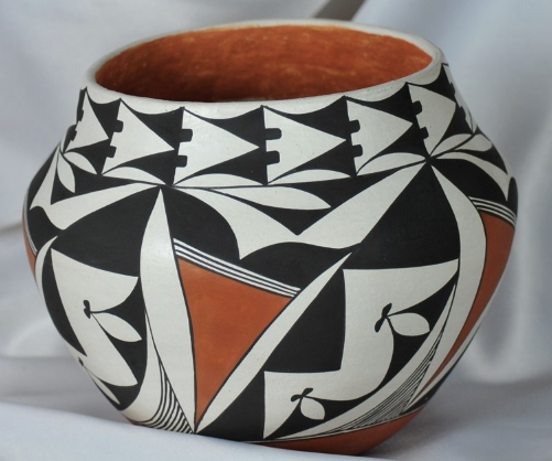 Black-and-white geometric ceramic pot with orange interior and accents