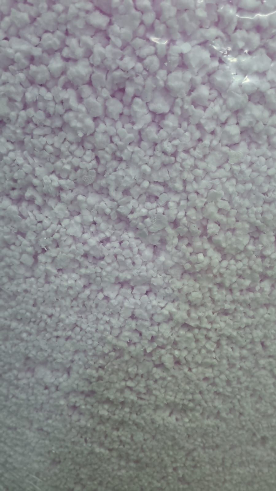 Pale purple, granular texture, possibly foam or crystals.