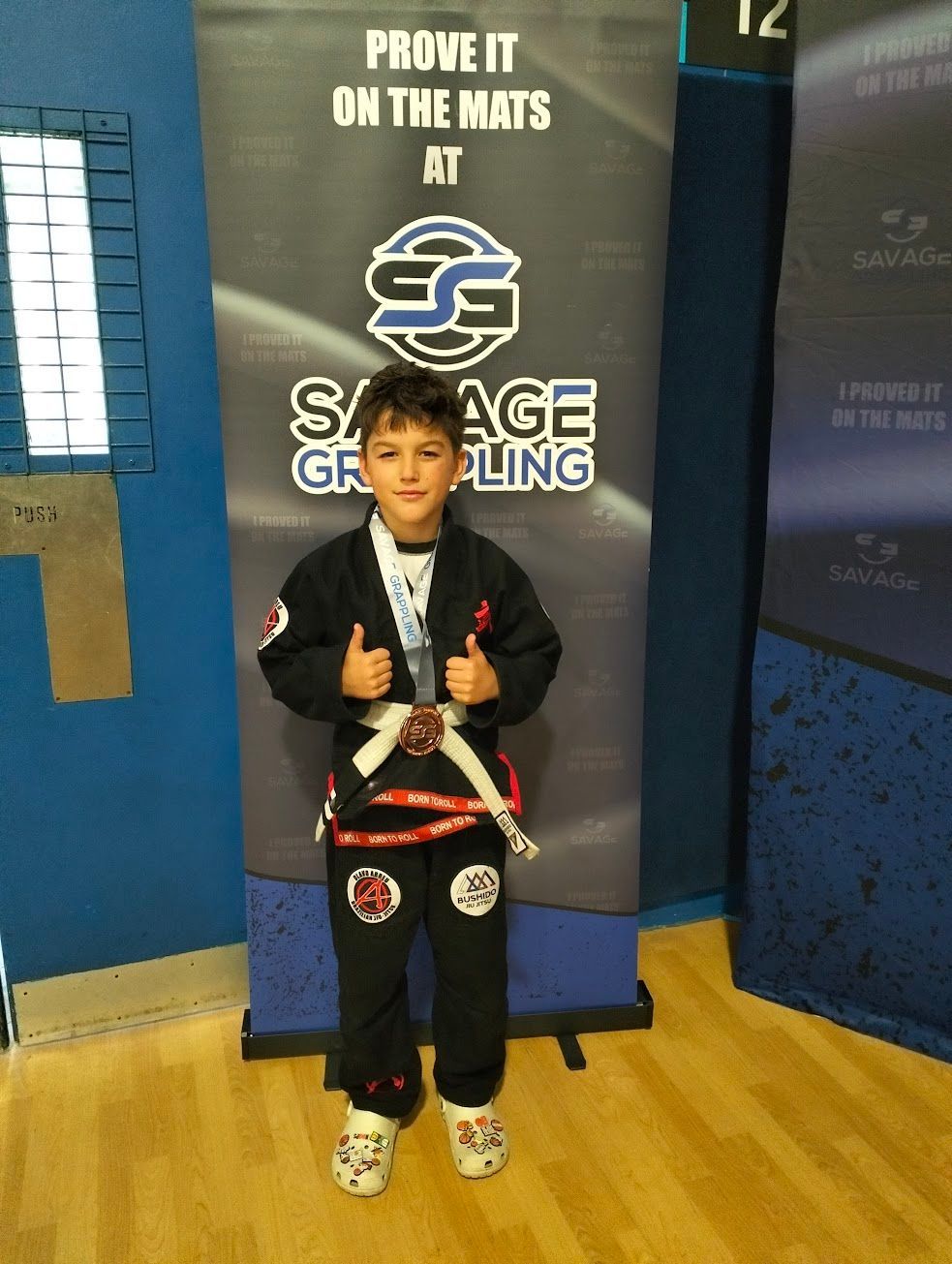 Young Bushido Academy BJJ competitor with medals