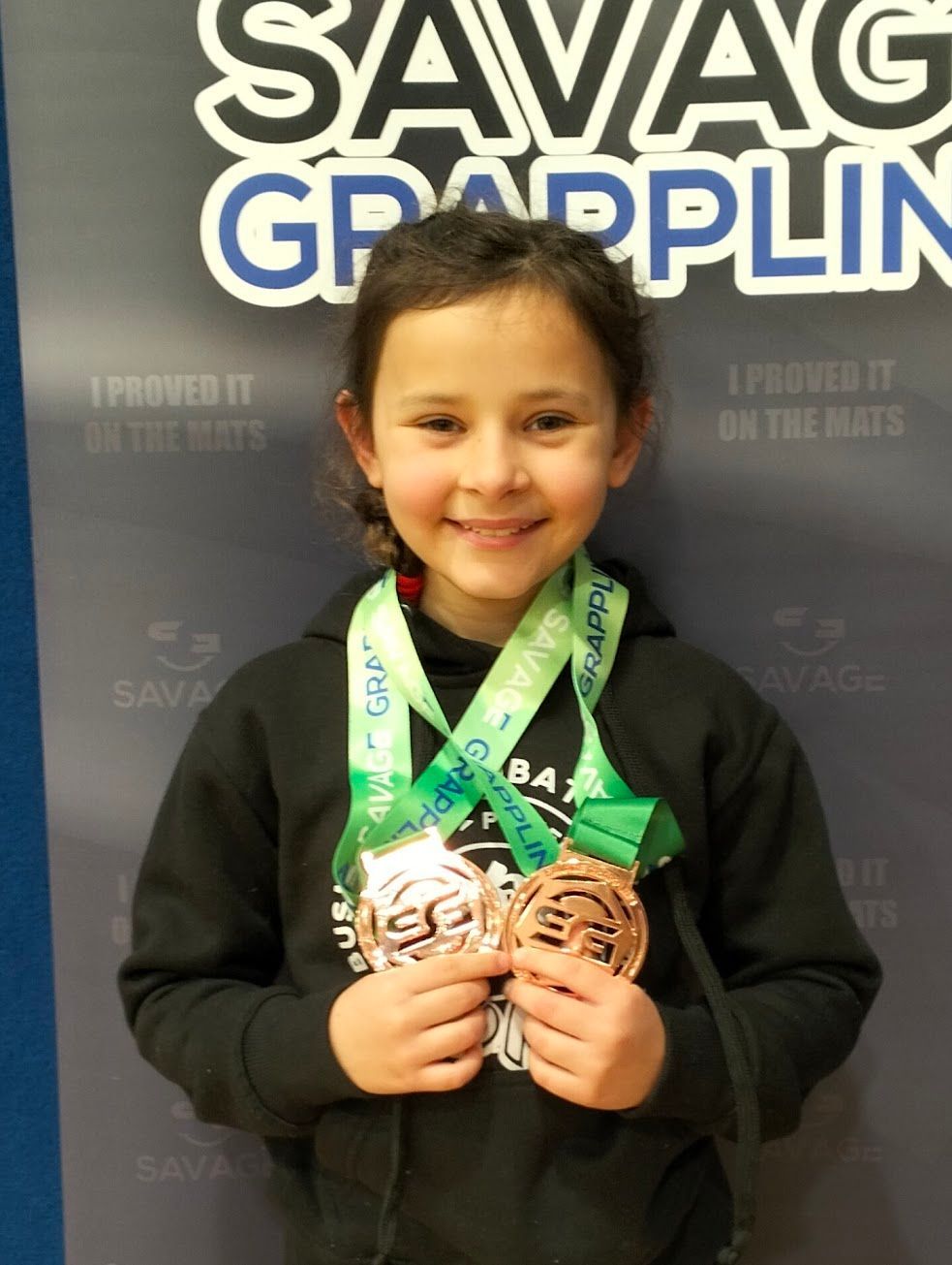 Young Bushido Academy student smiling with her medals