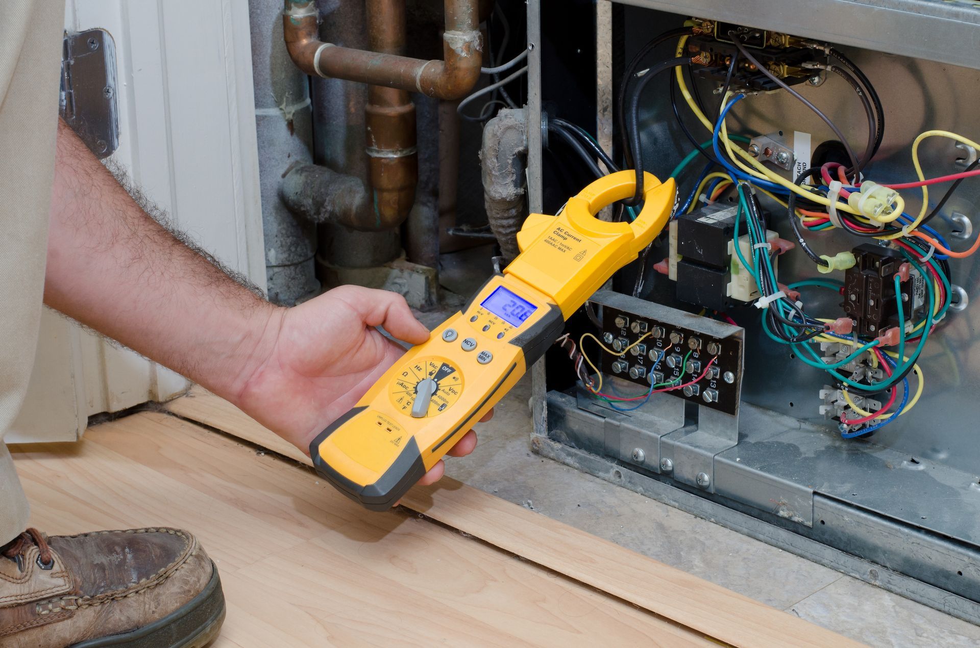 A man operates a tester to an HVAC, demonstrating effective heat pump repair in Johnson City 