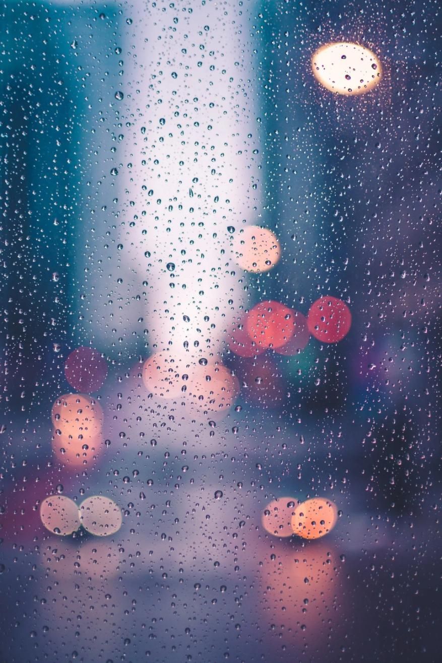 A Blurry Picture of Rain Drops on A Window with Lights in The Background — City Glass Newcastle in Jewells, NSW