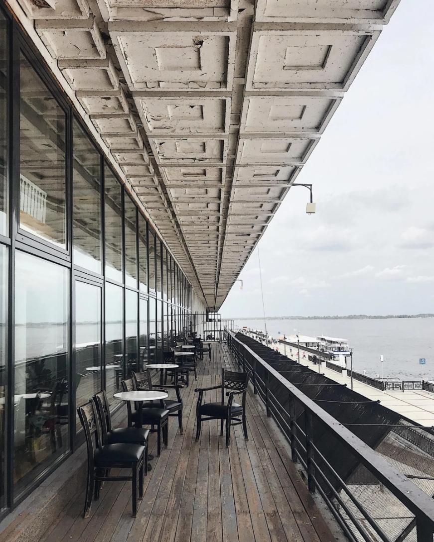 A Balcony with Tables and Chairs Overlooking a Body of Water — City Glass Newcastle in Jewells, NSW