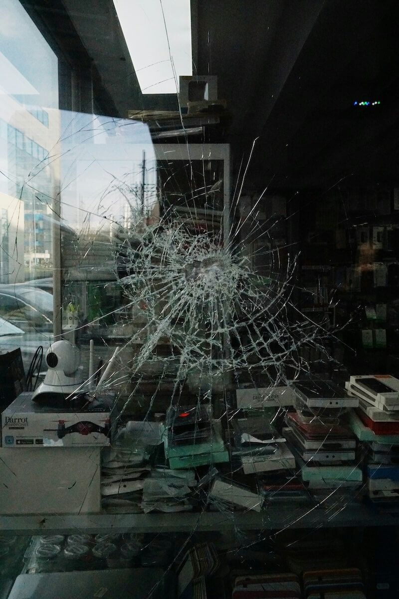A broken glass window in a store filled with electronics — City Glass Newcastle in Jewells, NSW