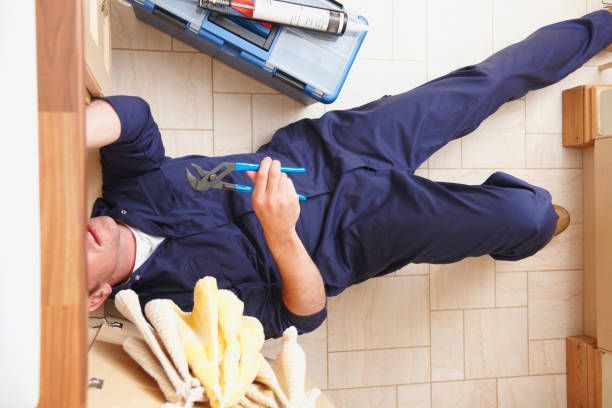 Person lying on a tiled floor beside a wooden table, near spilled cleaning supplies and bottles.