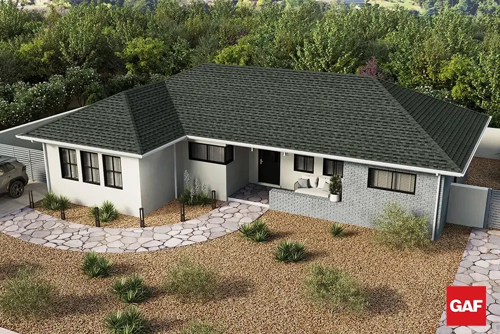Single-story white house with dark green roof, front windows, stone walkway, and desert landscaping