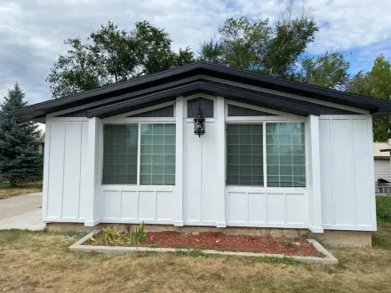 White house with black trim and two large windows.