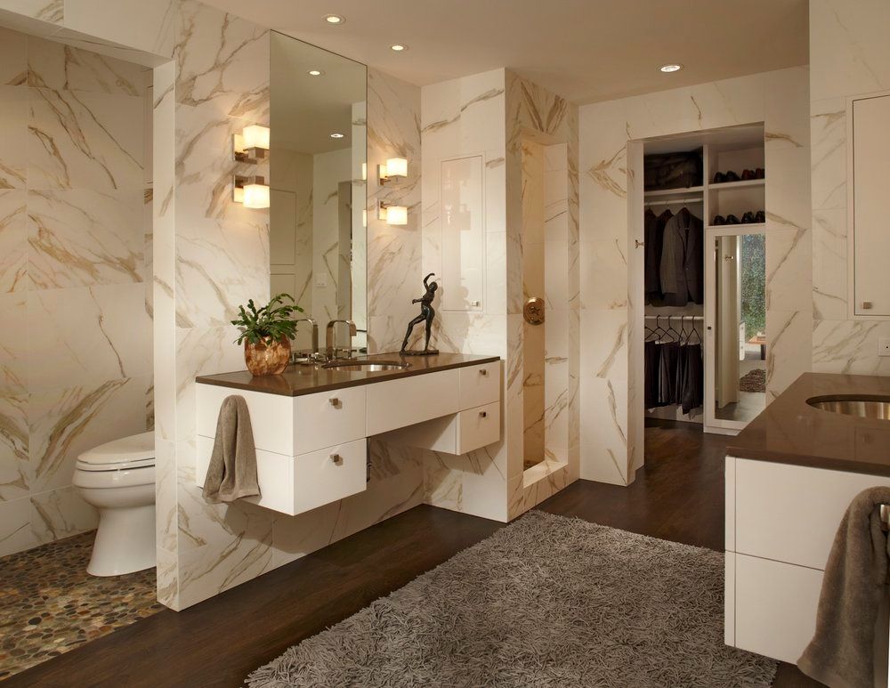 Modern bathroom with marble walls, floating vanity, and walk-in closet. Lakewood Bathroom renovation.