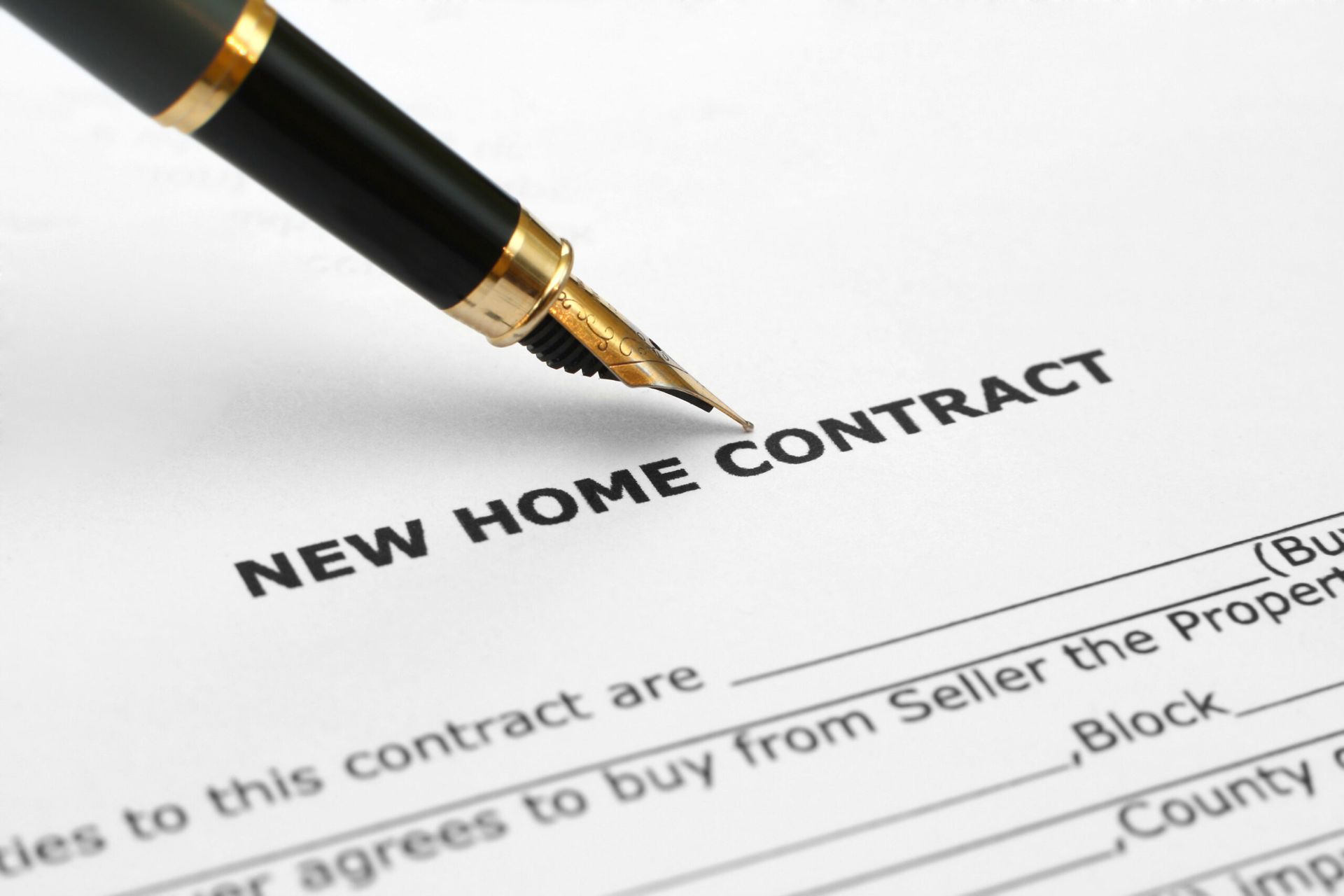 a pen is sitting on top of a new home contract