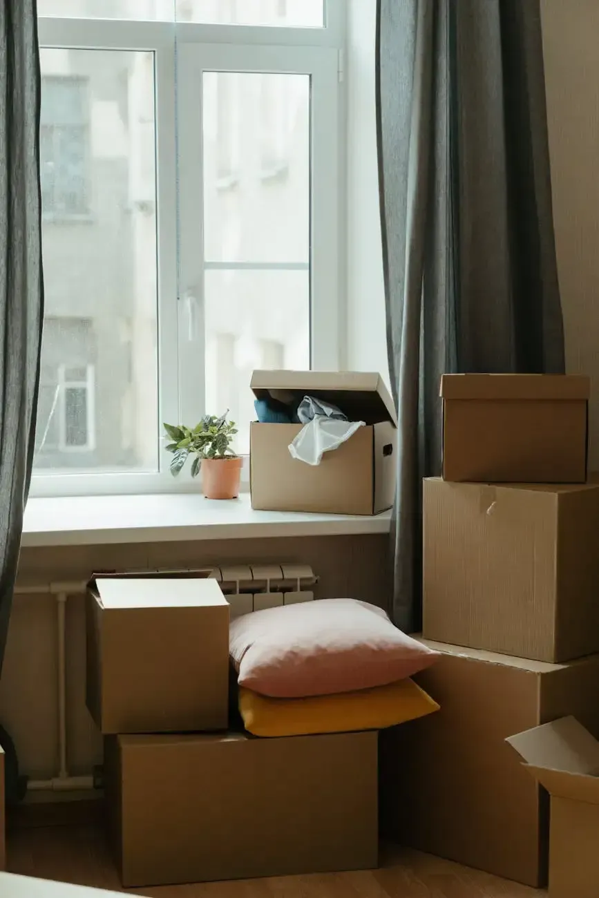Packed moving boxes and pillows by a bright window in a cozy room