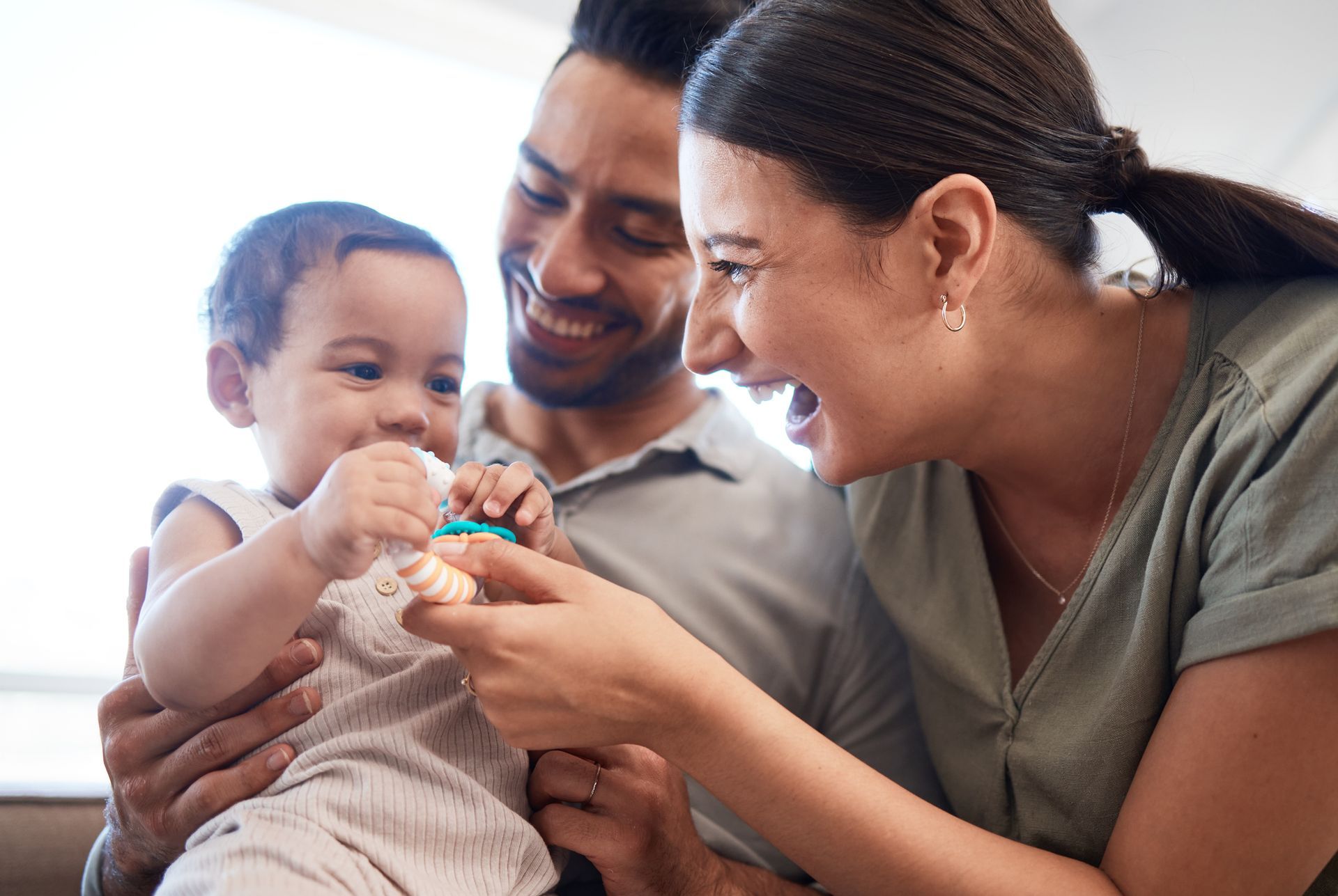 A man and a woman are holding a baby in their arms.