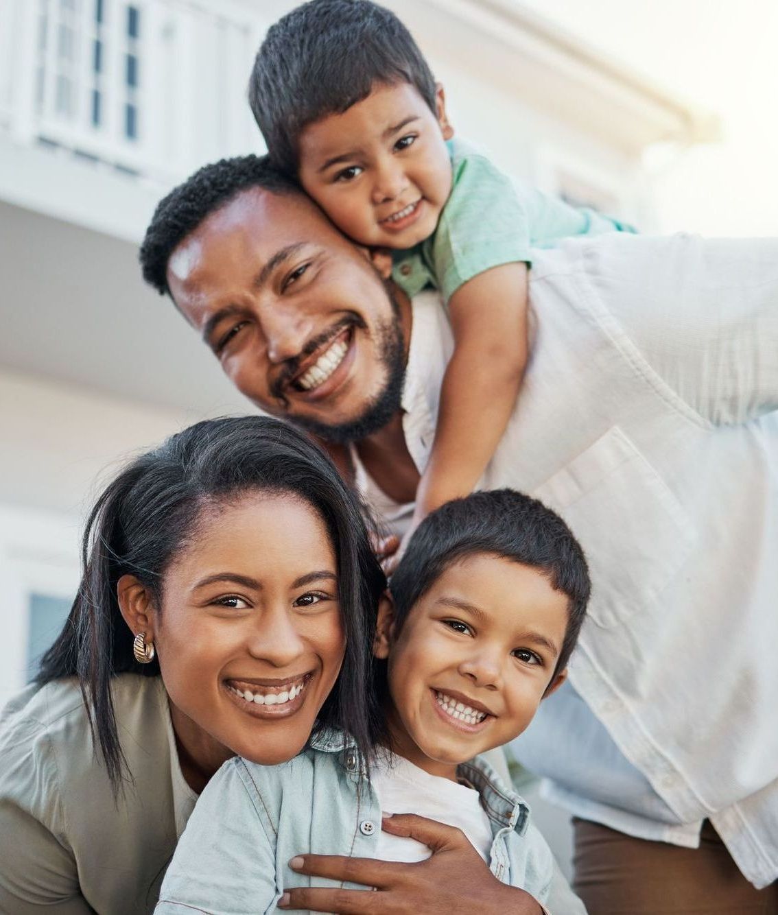 A family is posing for a picture in front of a house.