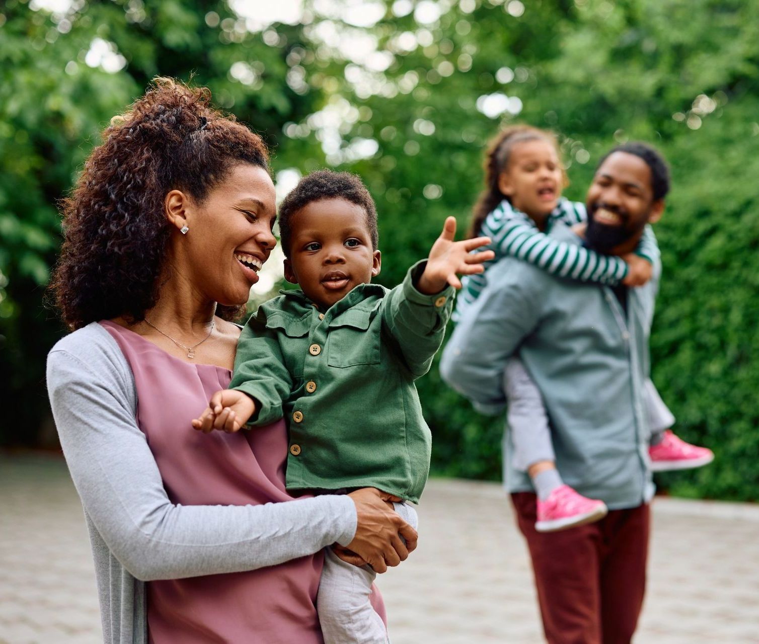 A family is standing next to each other in a park.