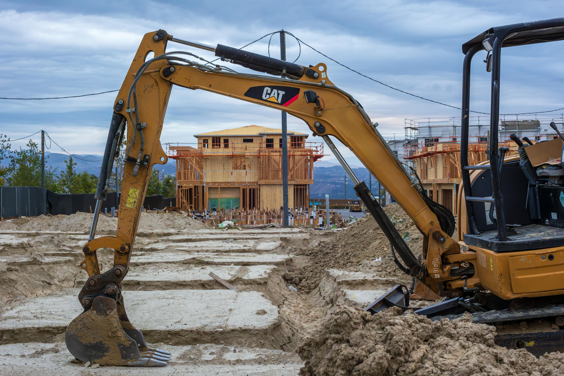Yellow excavator working on muddy construction site