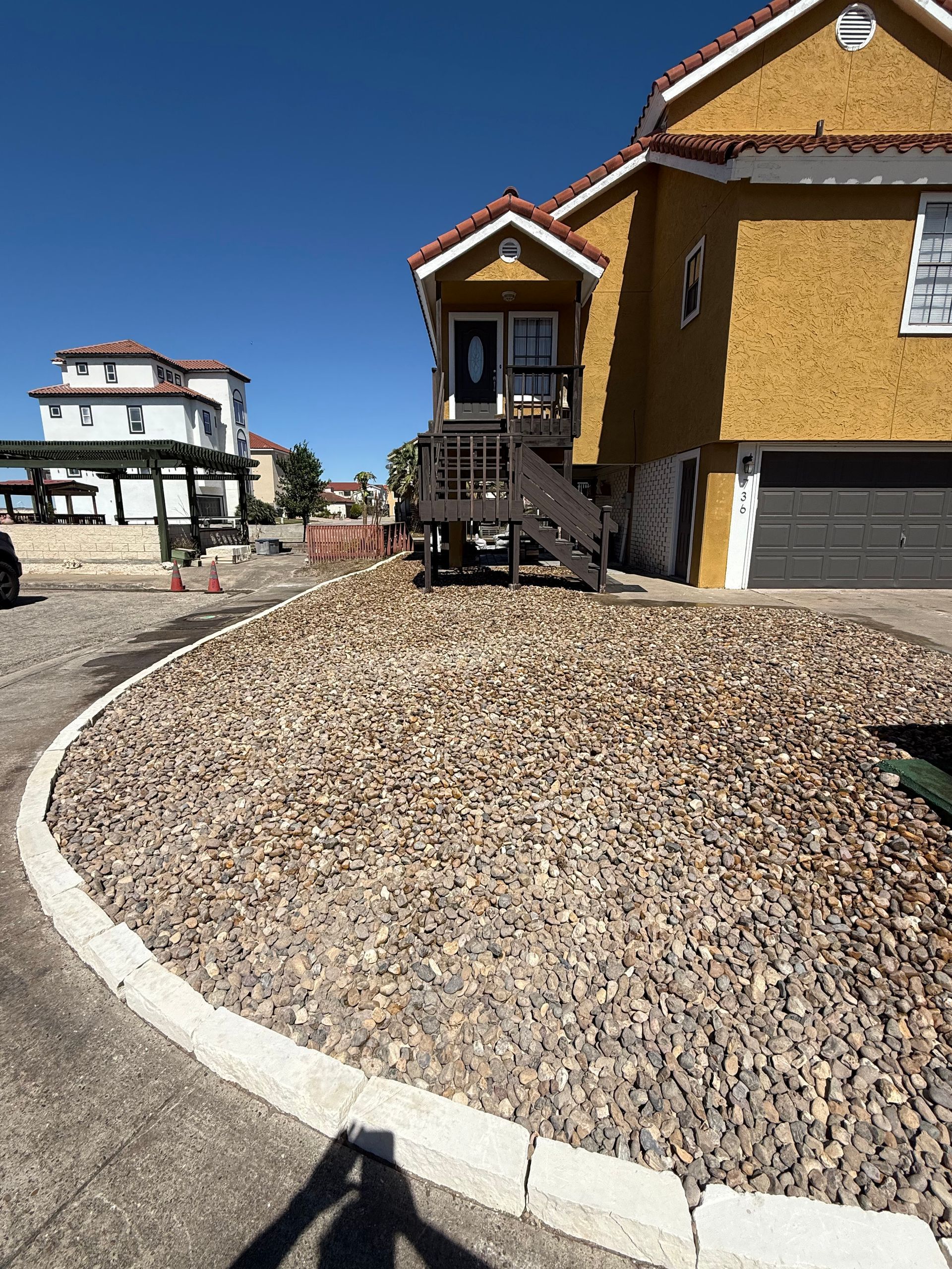 A man is digging in the ground with a shovel in a yard.