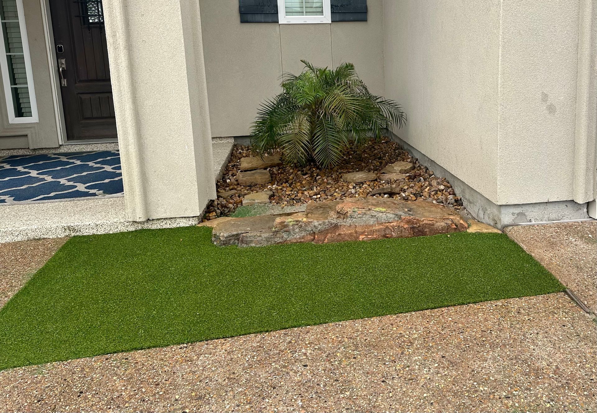 There is a rug on the ground in front of a house.