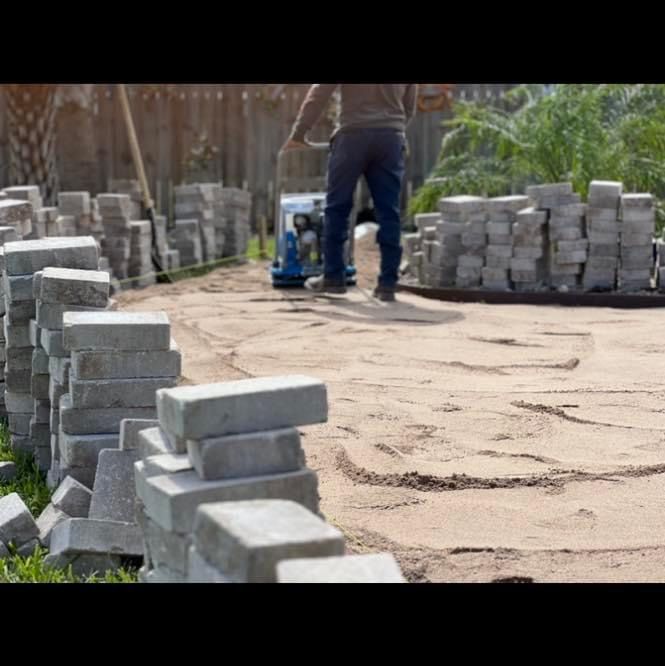 A man is standing in front of a pile of bricks.