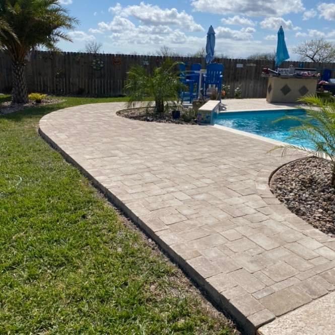 A brick walkway leading to a swimming pool
