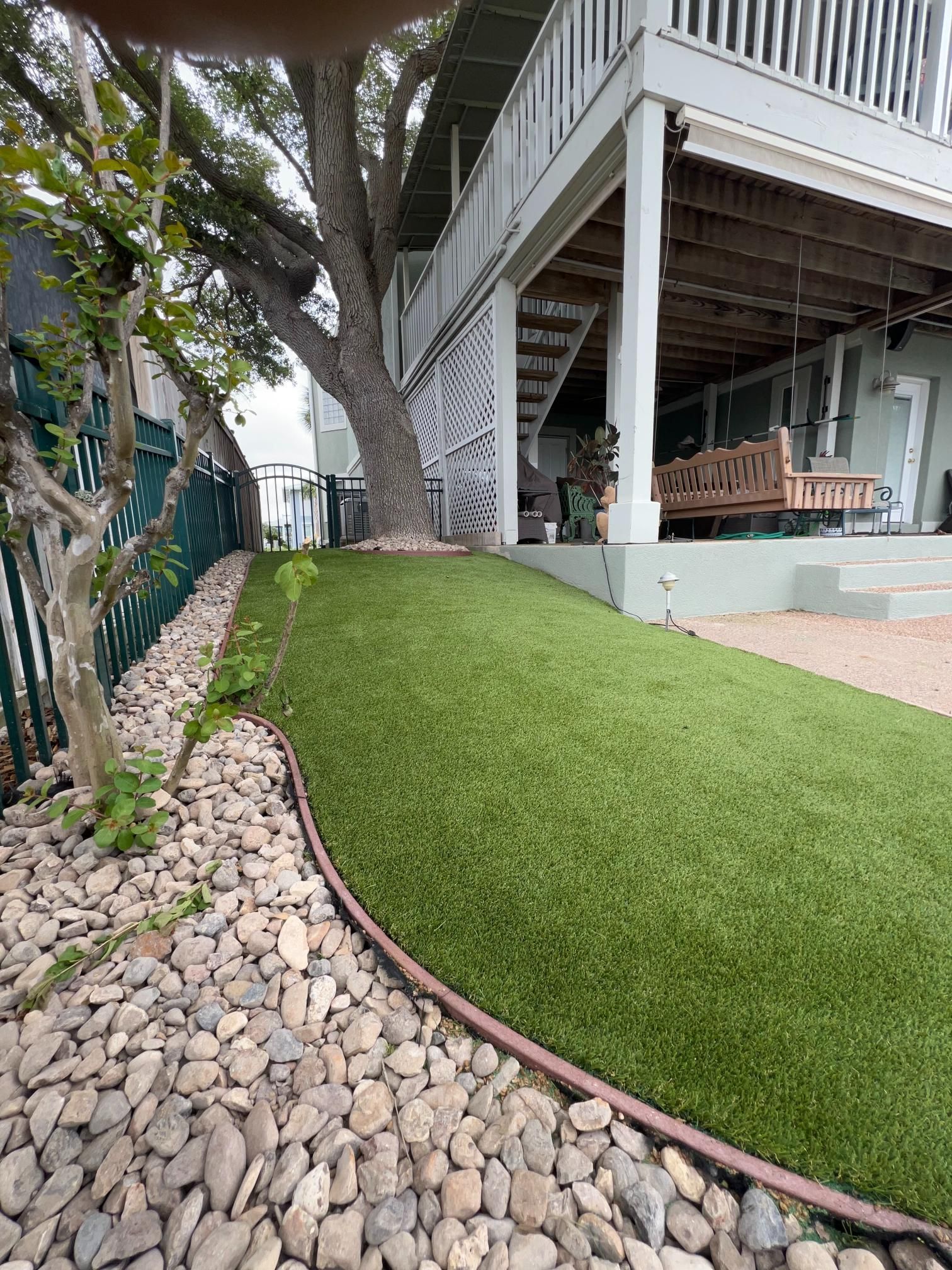 A house with a lush green lawn and rocks in front of it.
