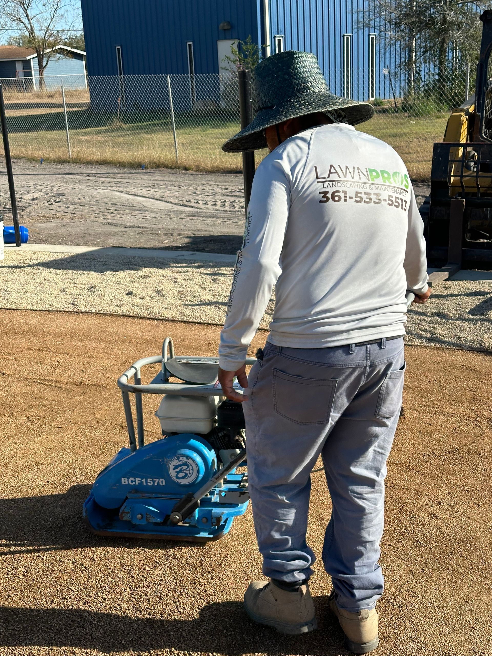 A man wearing a hat is standing next to a machine.