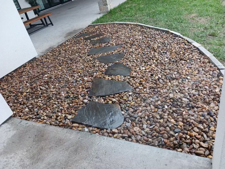 A concrete walkway surrounded by rocks and gravel.
