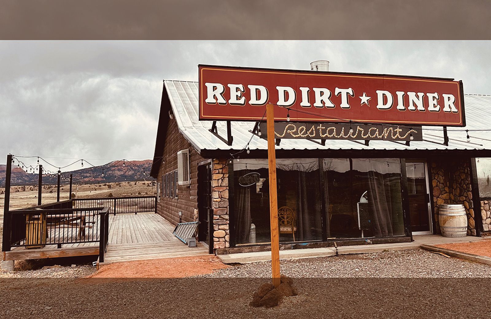 A red dirt diner restaurant is located in the desert.
