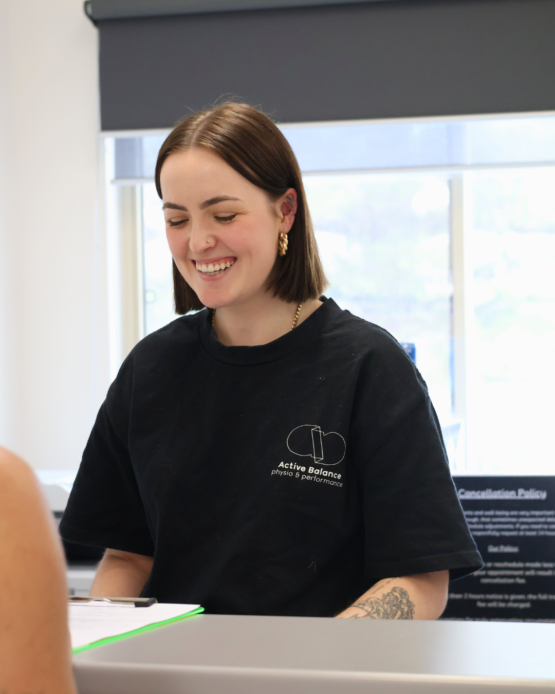 Receptionist helping client at Active Balance Physio & Wellness