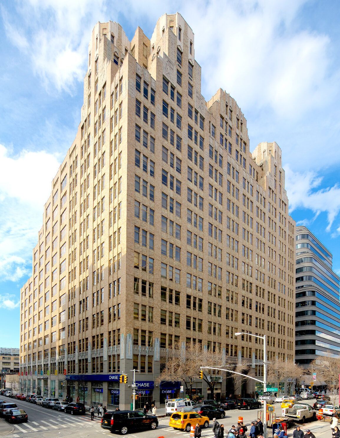 A large building with a lot of windows is in the middle of a city