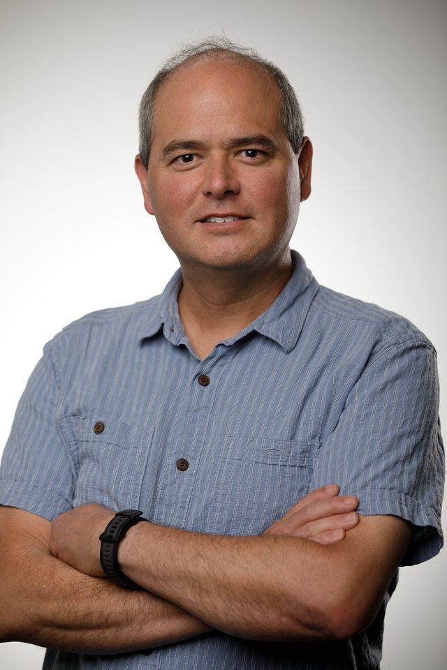 A man in a blue shirt with his arms crossed