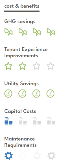 A man is standing in front of a building looking at a tablet.
