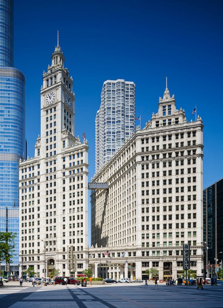 A large white building with a clock tower in the middle of a city