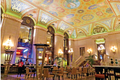 A restaurant with tables and chairs and a colorful ceiling