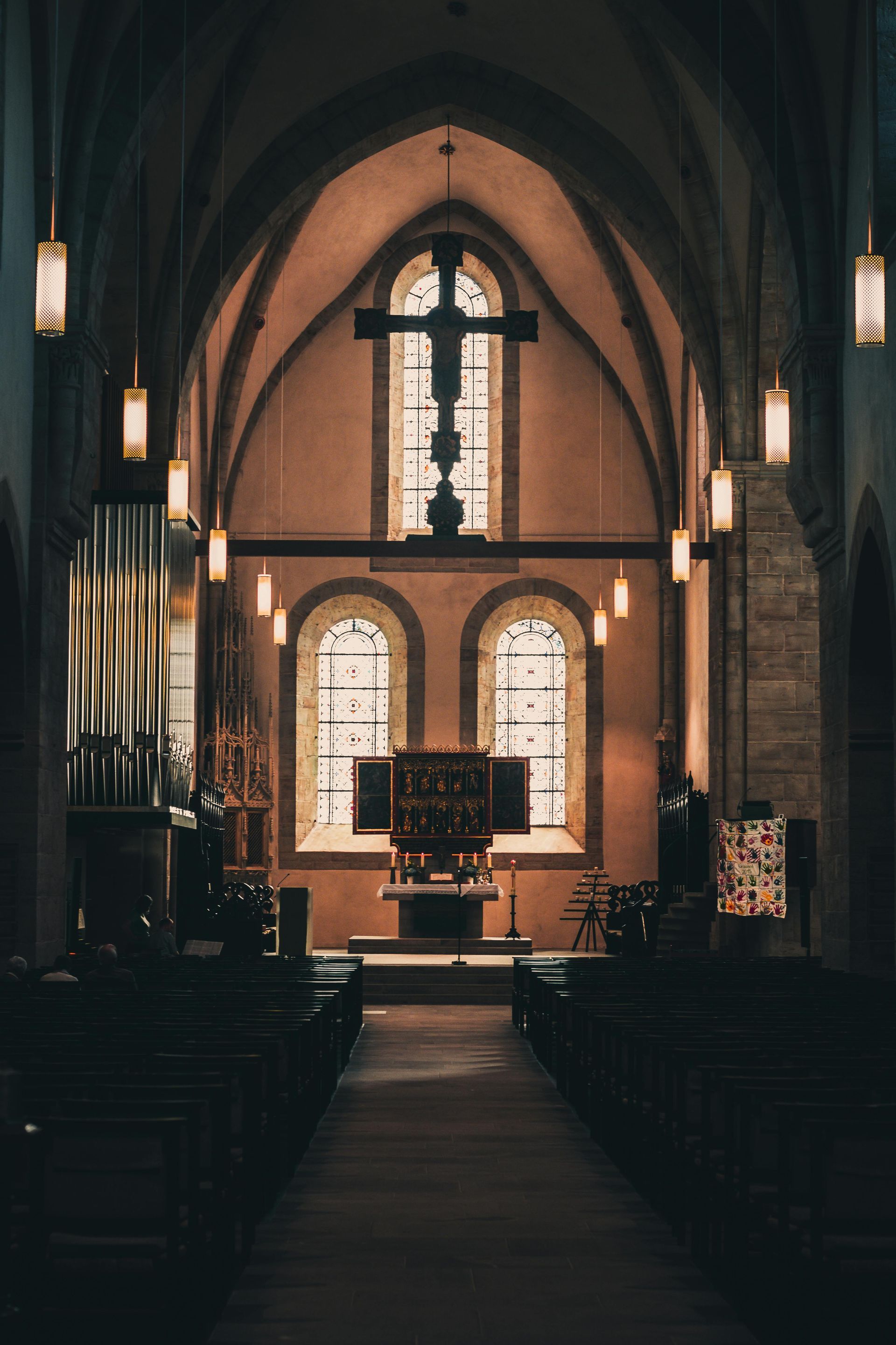 The inside of a church with a cross on the ceiling.