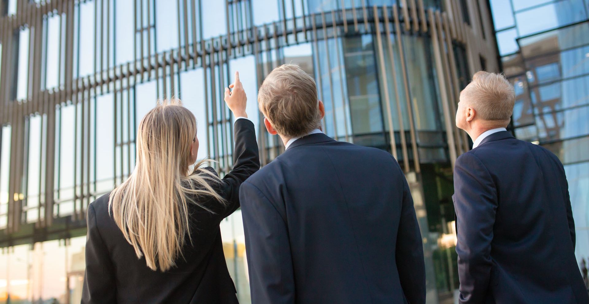 A group of business people are looking at a building.