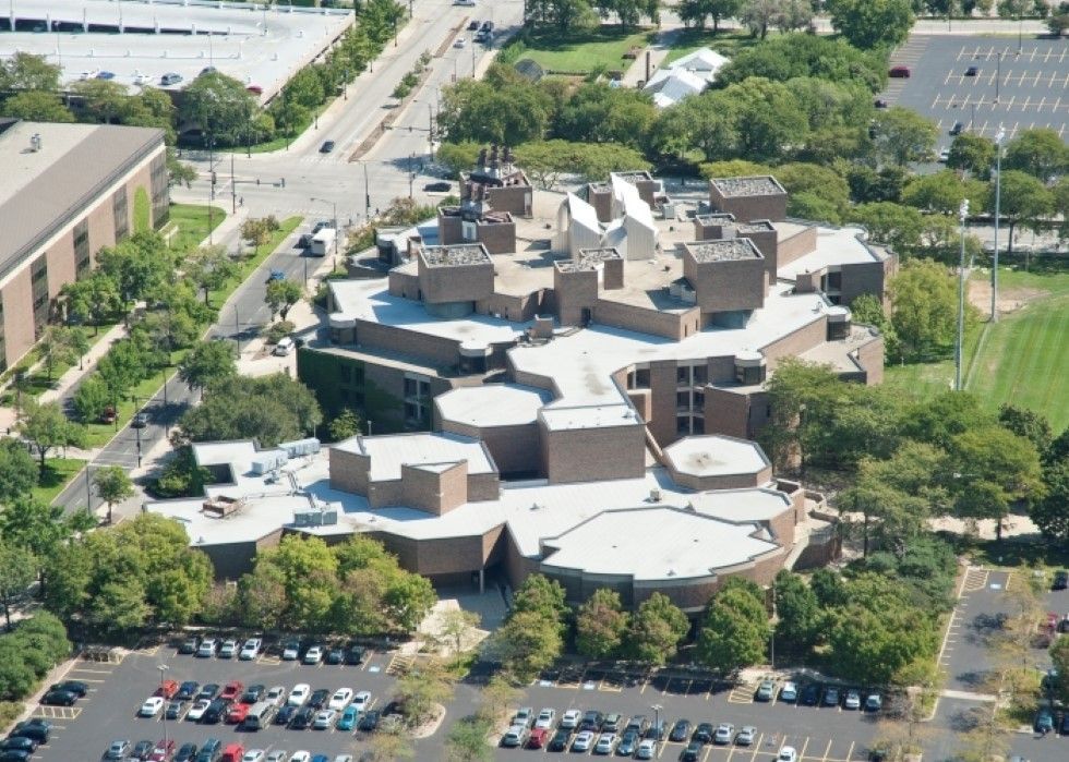 An aerial view of a large building with a parking lot in front of it