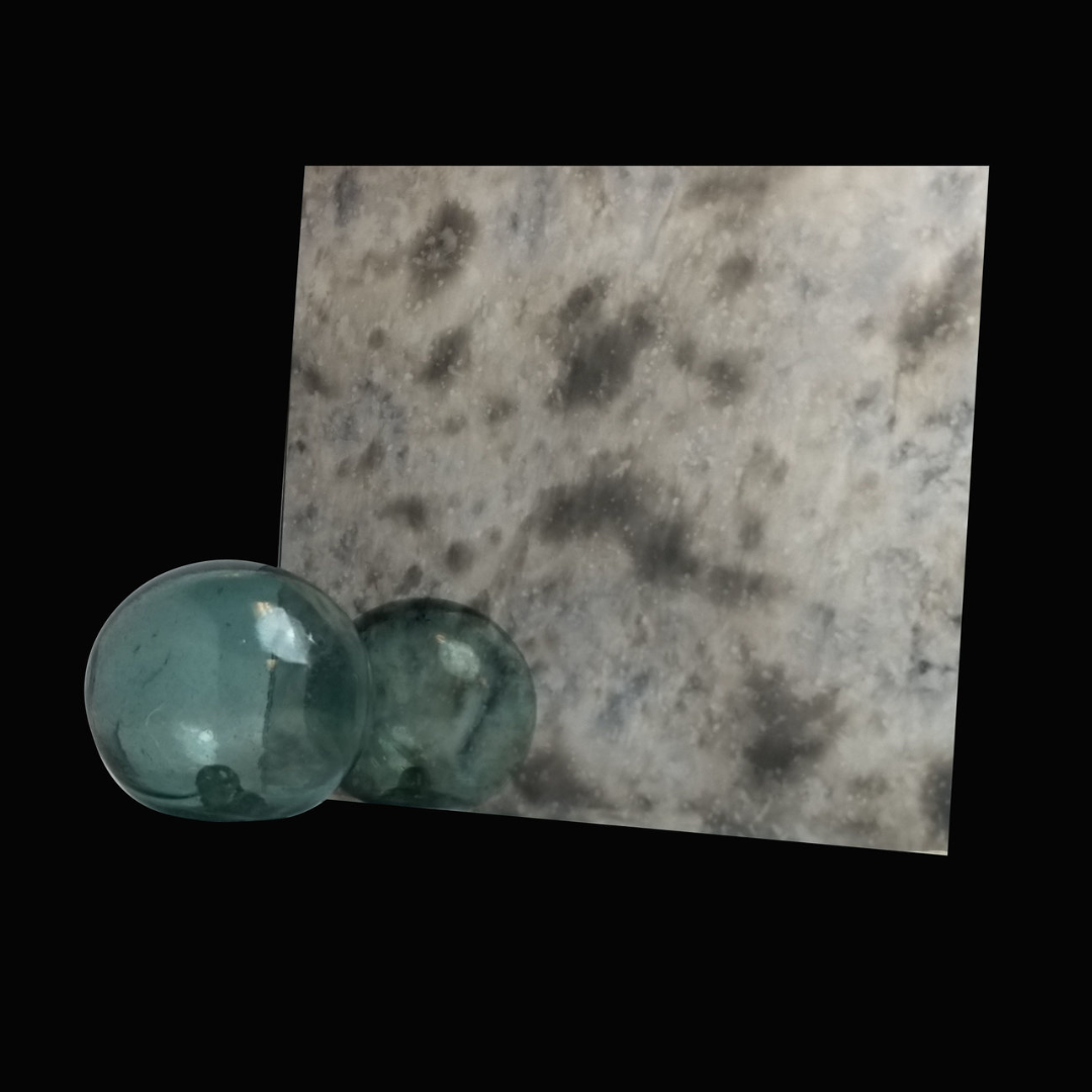 Two glass balls are sitting next to a mirror on a black background.
