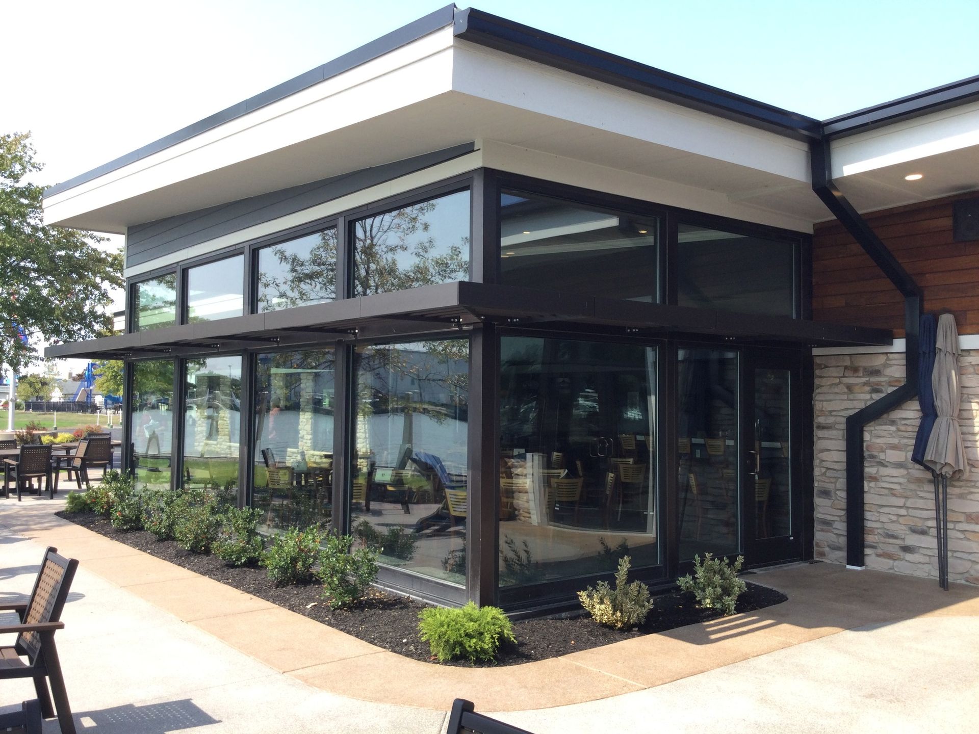 A large building with a lot of windows and a patio in front of it.