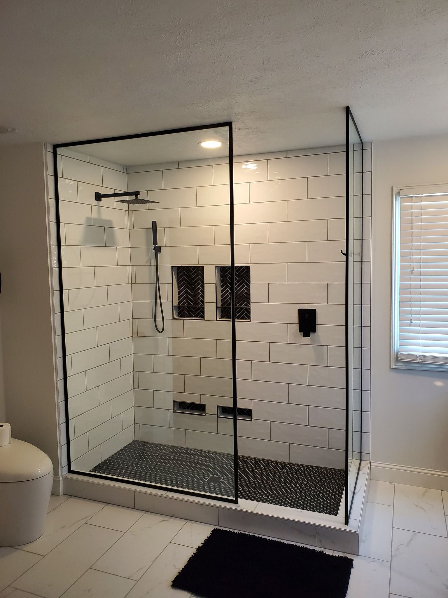 A bathroom with a walk in shower and a toilet