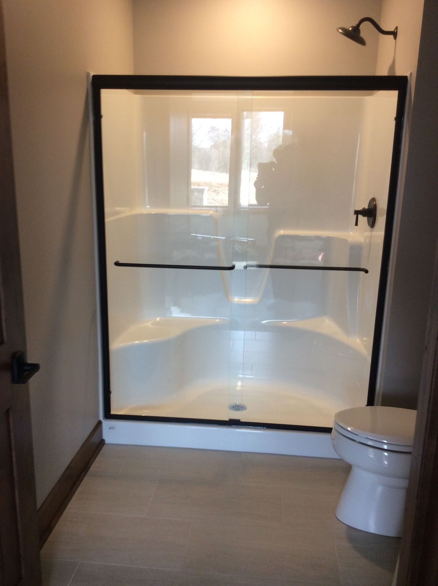 A bathroom with a sliding glass shower door and a toilet.