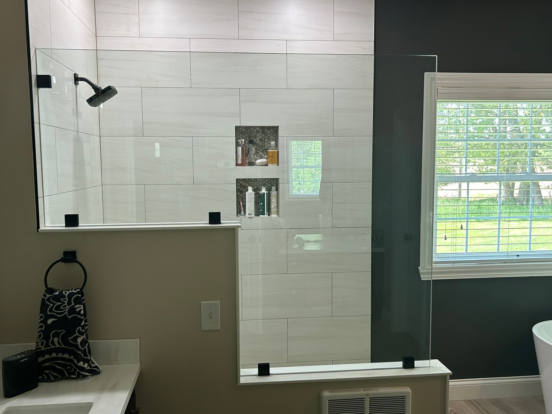 A bathroom with a walk in shower and a window