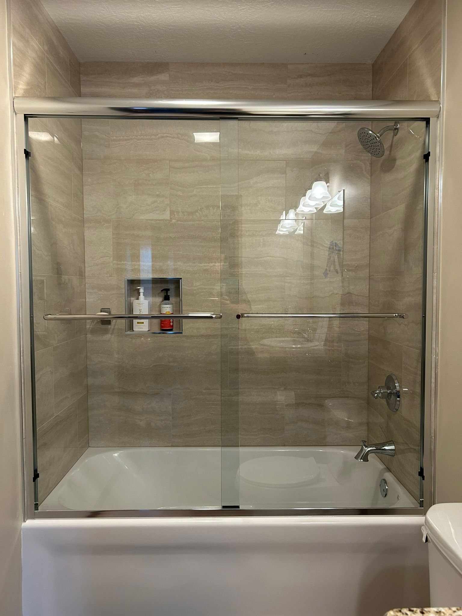 A bathroom with a bathtub and a sliding glass shower door.