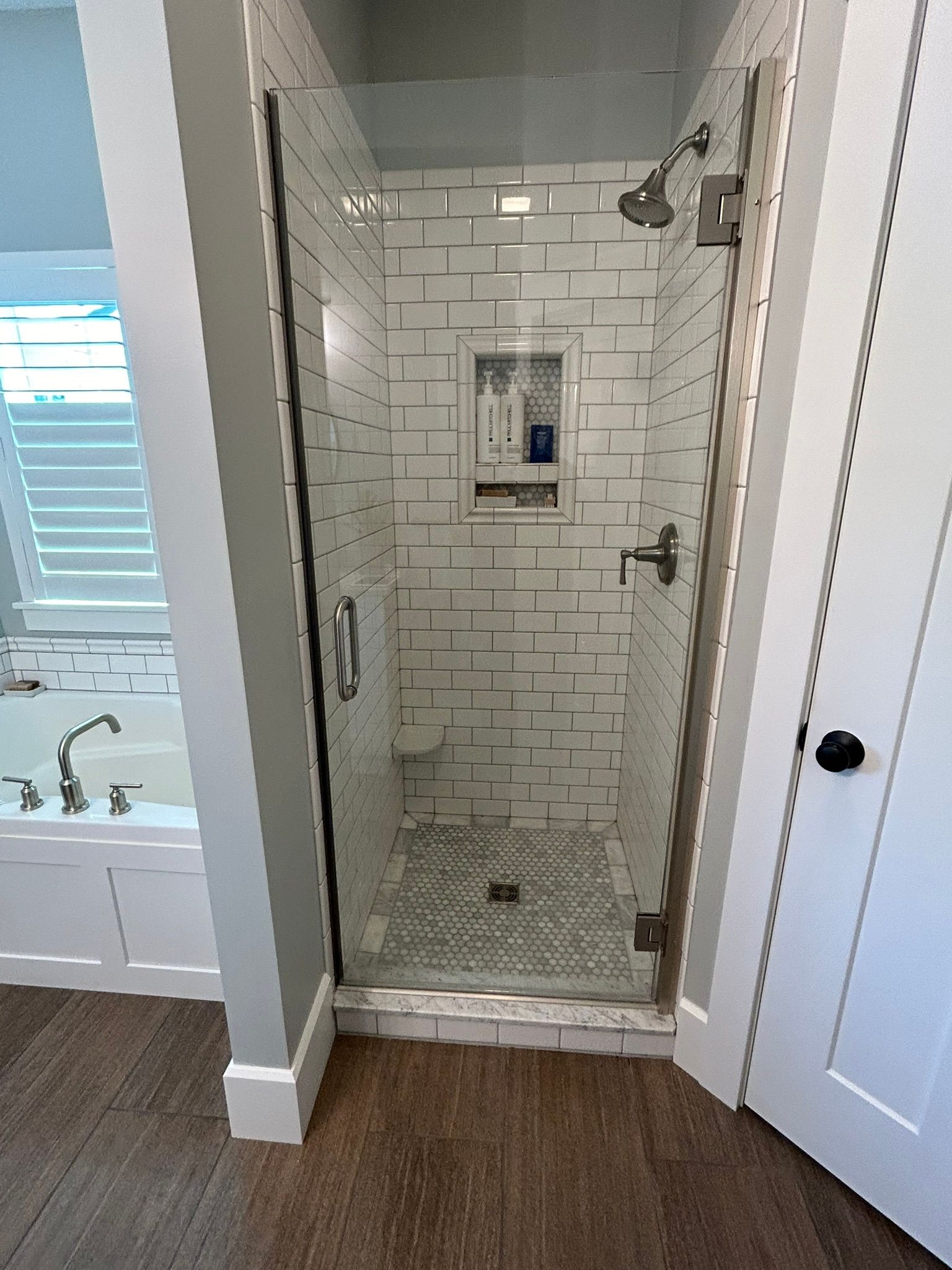 A bathroom with a walk in shower and a bathtub.
