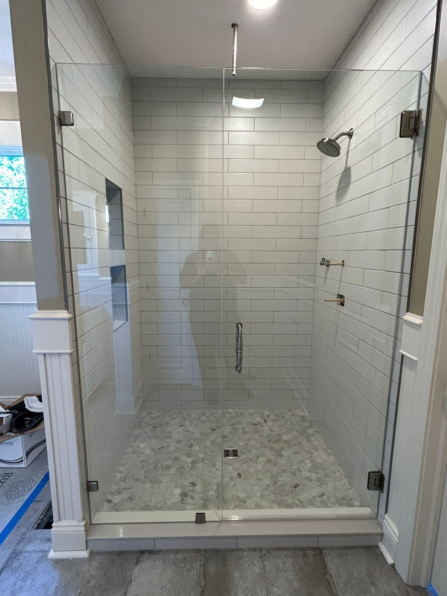 A bathroom with a walk in shower with a glass door.