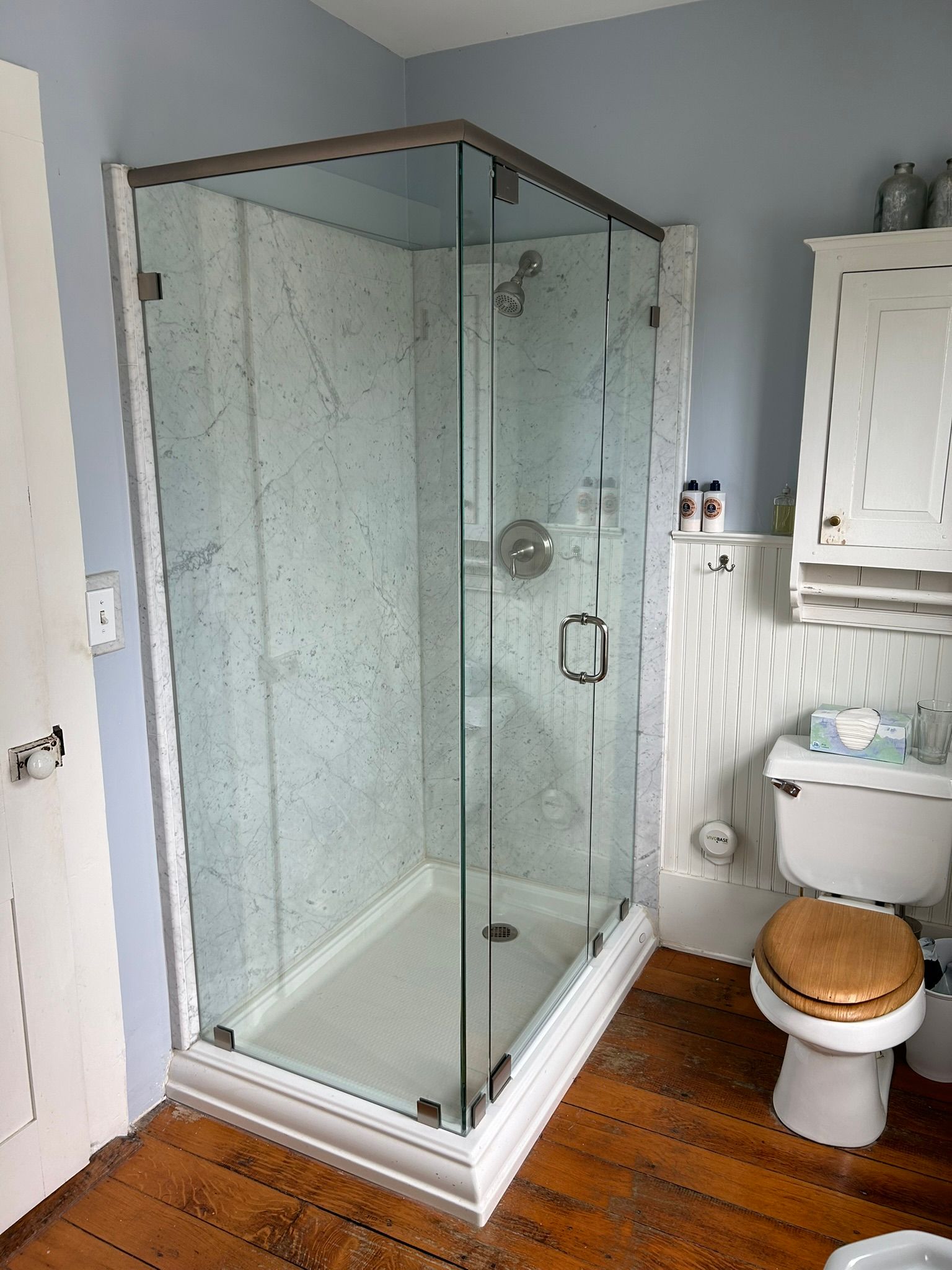 A bathroom with a toilet and a shower stall with a glass door.
