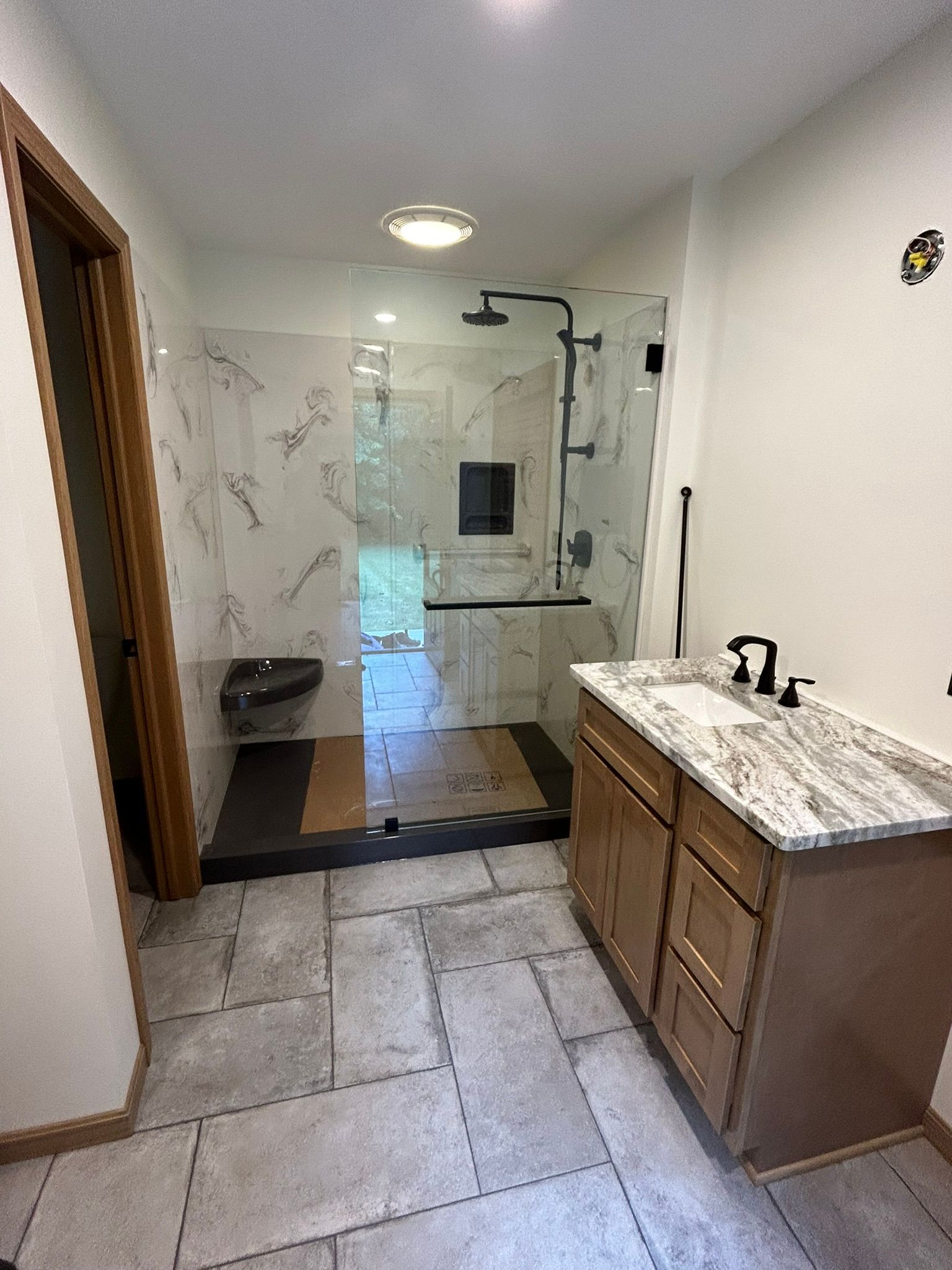 A bathroom with a sink and a walk in shower.