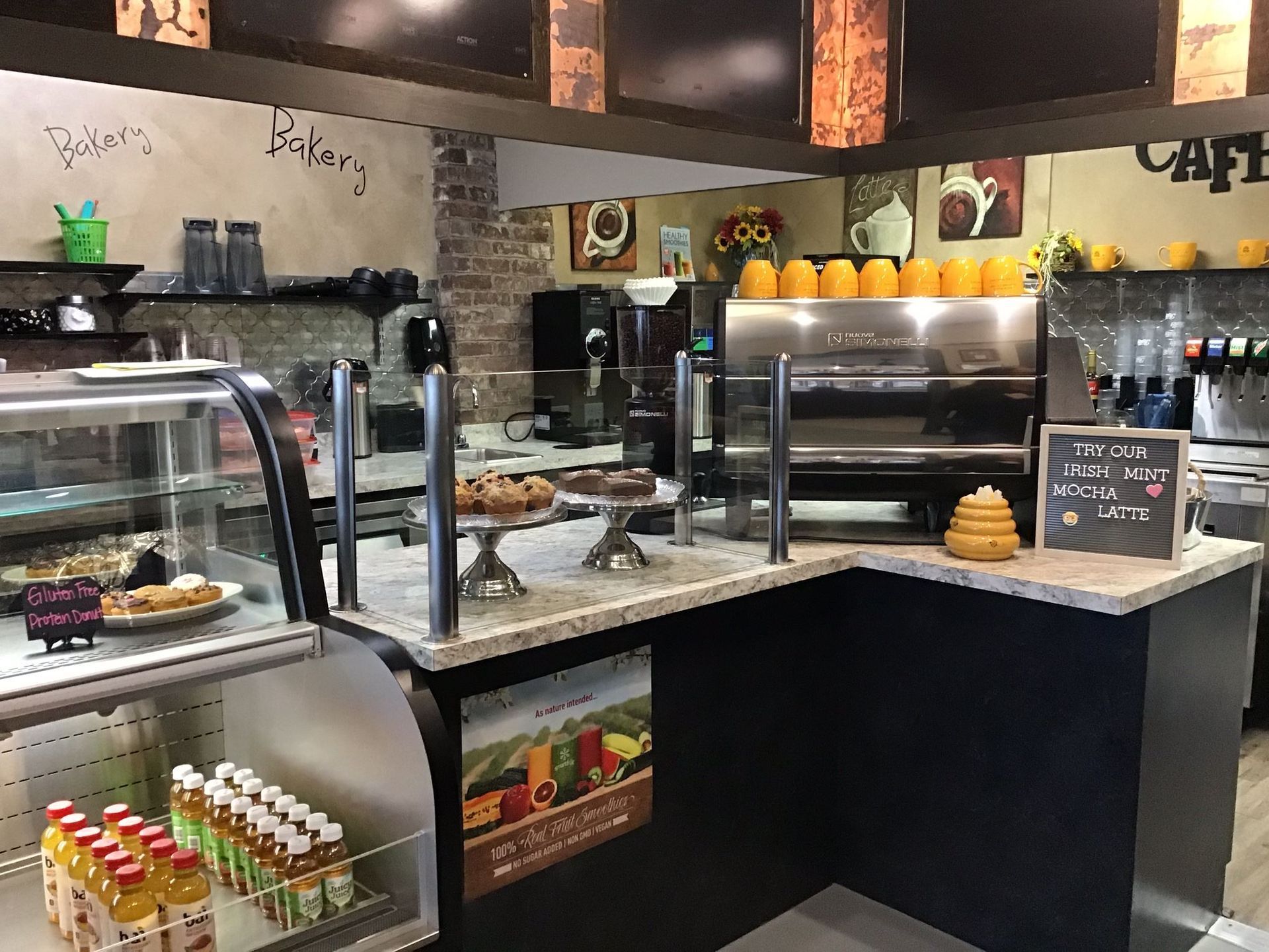 A restaurant with a counter and a display case filled with food and drinks.