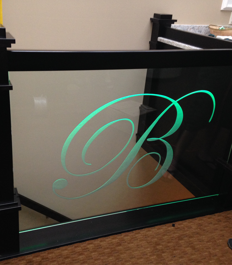 A green letter b is on a glass railing