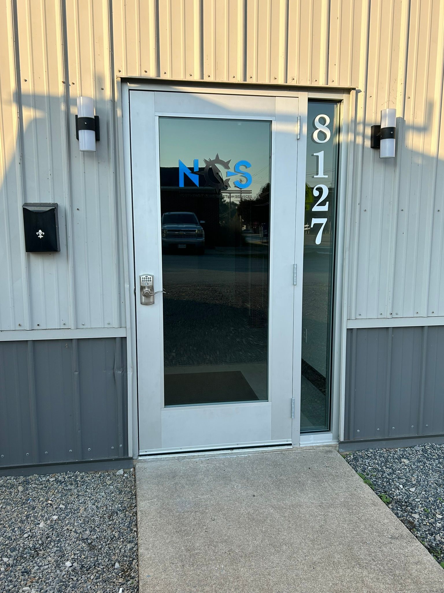 Entrance to a building with a glass door. Address 