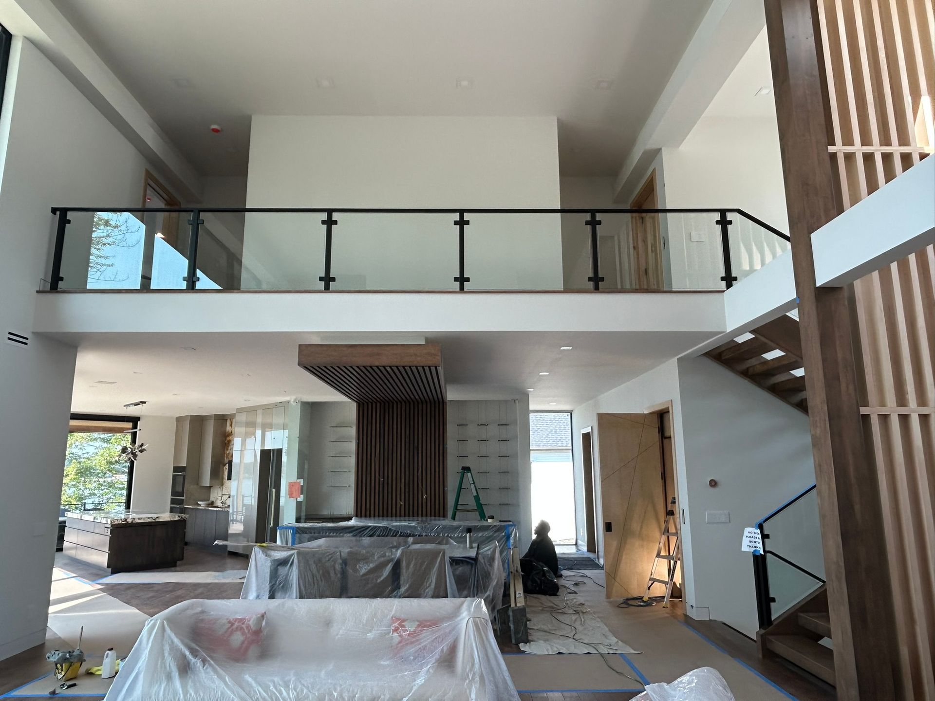 Interior view of a two-story home with a balcony, staircase, and open layout.