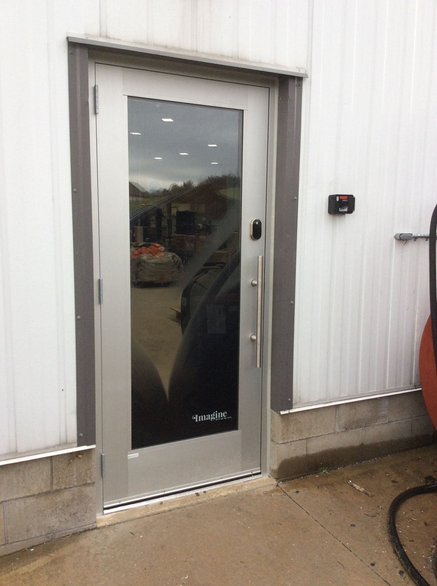 Exterior door with glass panel, stainless steel frame. Electronic keypad on the wall.